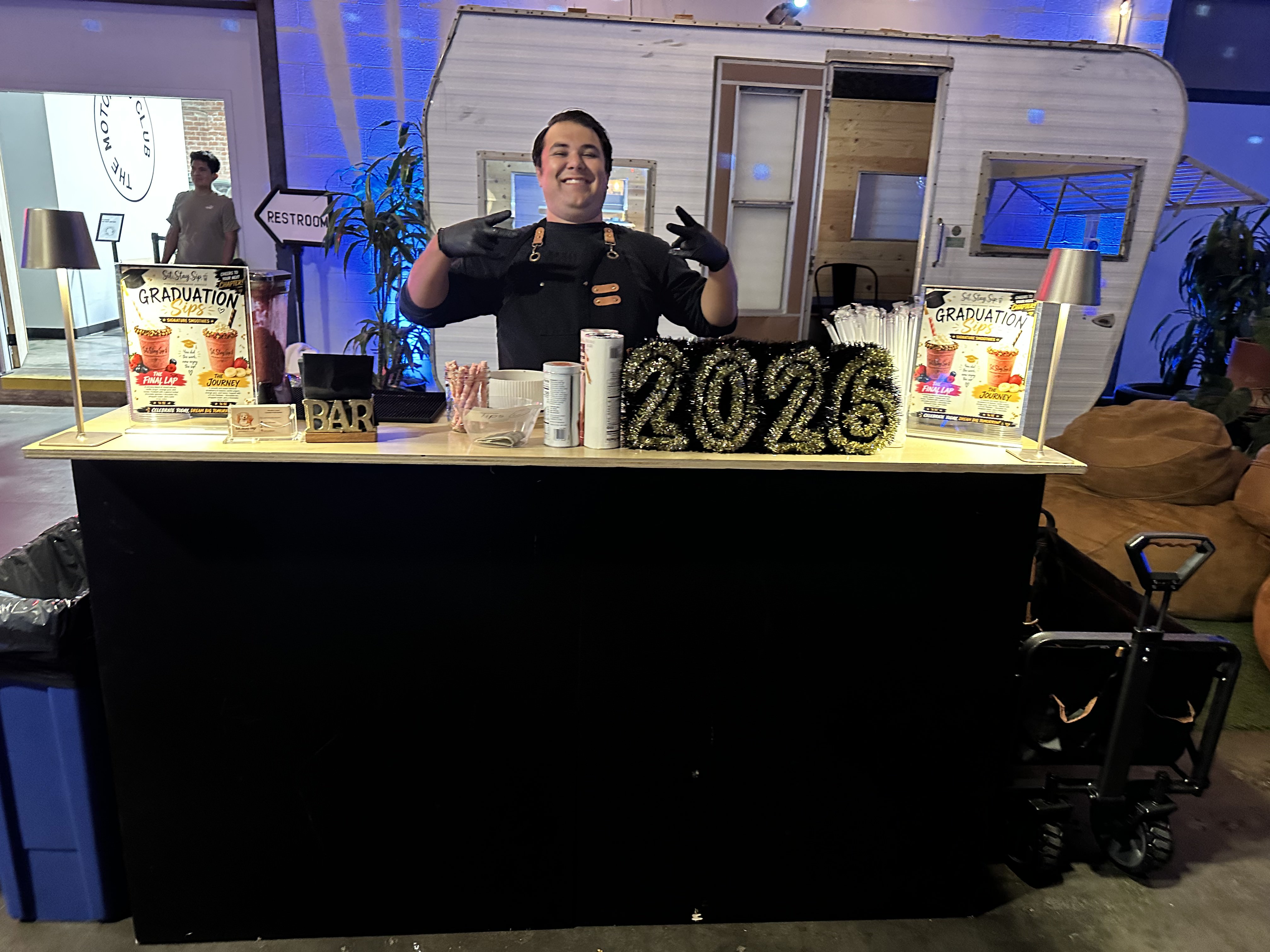 Abrahan behind the Graduation Sips smoothie bar