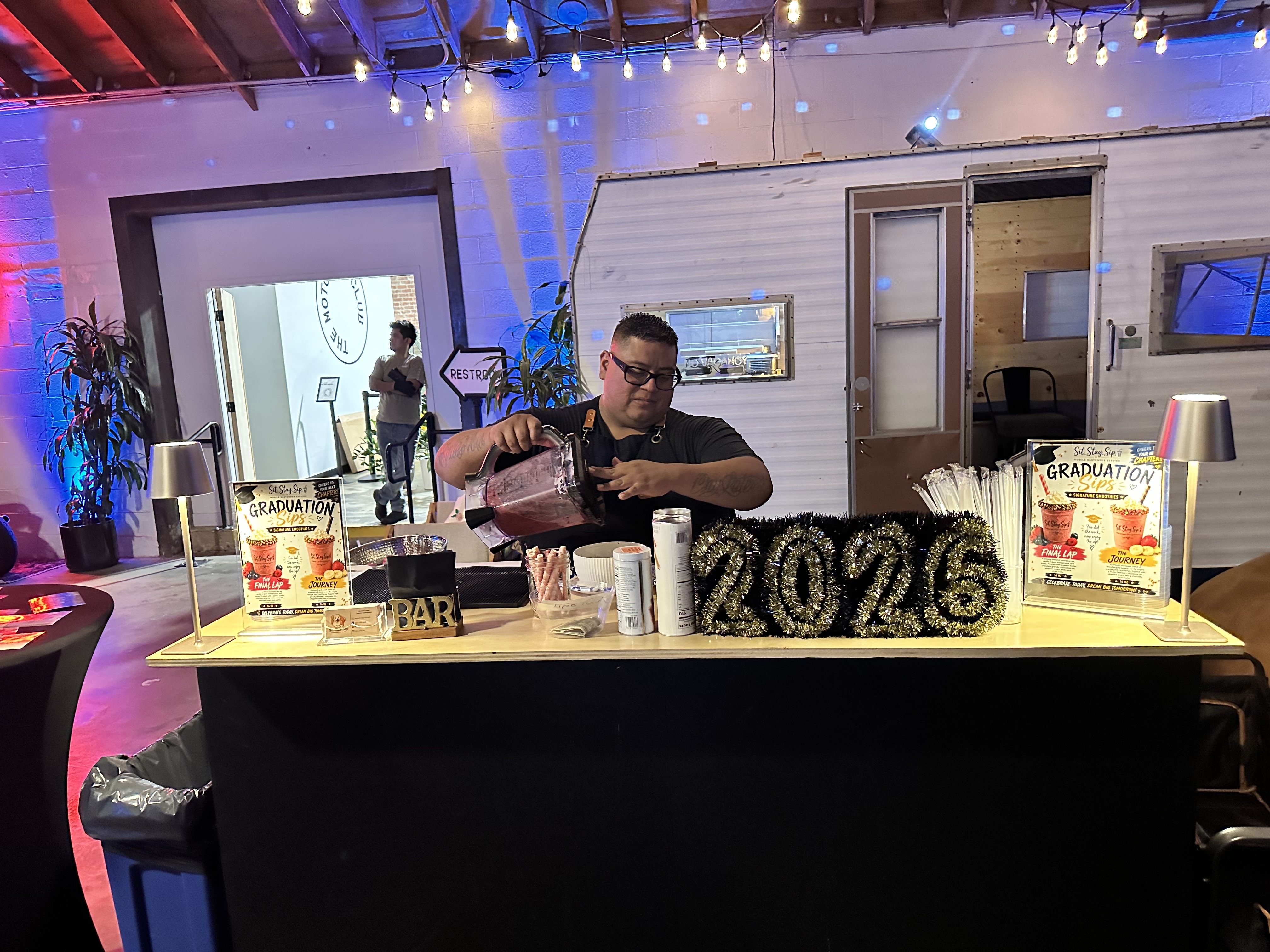 Pouring smoothies at the graduation event